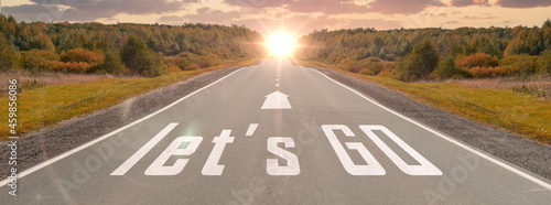 word let's go written on highway road in the middle of empty asphalt road at beautiful sunset sky. concept for business planning, strategy and challenge or career path, opportunity and change