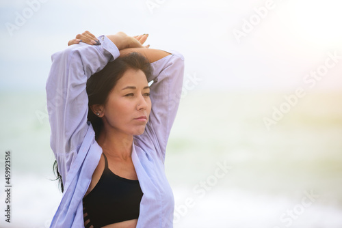 A portrait of beautiful woman stretching her arms up. Healthy wellness lifestyle. Spiritual health. Personal fulfillment.