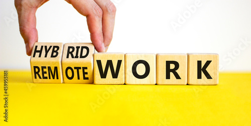 Hybrid or remote work symbol. Businessman turns cubes and changes words 'remote work' to 'hybrid work'. Beautiful white background. Business, hybrid or remote working concept, copy space.