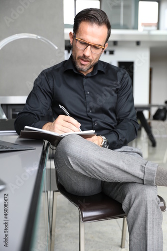 Biznesmen pracuje na laptopie. Praca biurowa przystojnego inwestora. 