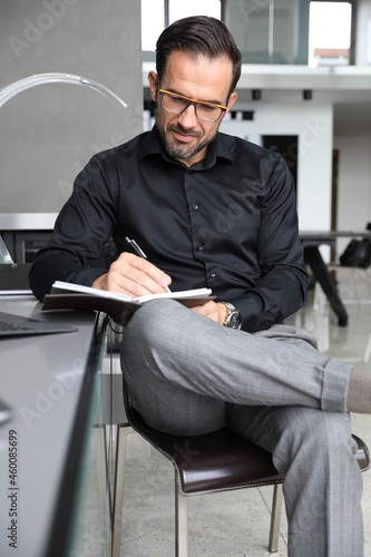 Biznesmen pracuje na laptopie. Praca biurowa przystojnego inwestora. 