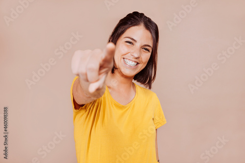 Smiling woman point finger at you, positive mood.