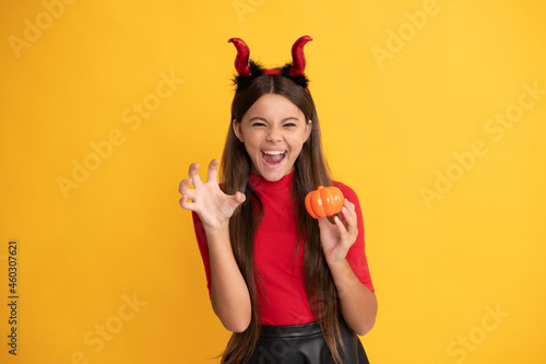 evil child in imp horns. happy halloween. devil kid with pumpkin. trick or treat.