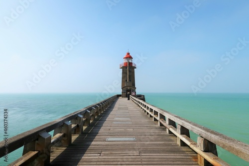 Paysage de mer à Fécamp, avec le phare de la pointe Fagnet au bout de la jetée, sur fond de ciel bleu, en Seine-Maritime / Normandie (France)