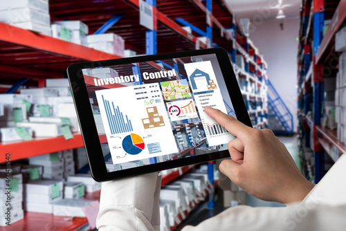 Warehouse management innovative software in computer for real time monitoring of goods package delivery . Computer screen showing smart inventory dashboard for storage and supply chain distribution .