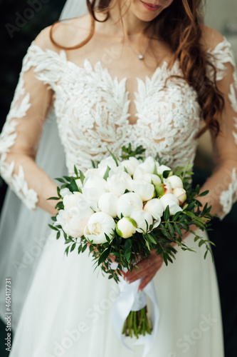 Beautiful wedding bouquet of flowers in hands of the bride