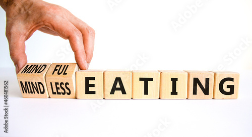 Mindful or mindless eating symbol. Doctor turns cubes and changes words mindless eating to mindful eating. Beautiful white background, copy space. Medical and mindful or mindless eating concept.