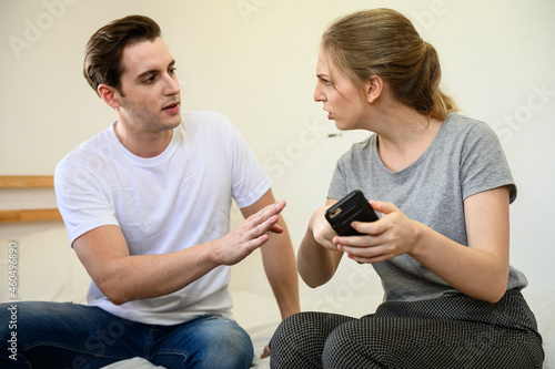 Young Caucasian woman feeling angry and quarrel with boyfriend after found hidden love affair evidence in smartphone. Love affair couple relation problem concept.