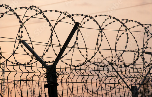 fence with barbed wire at the border of the property at sunset, protection against escaping terralists
