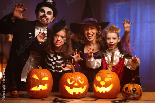 Young family mother father and children in Halloween costumes celebrating all hallows eve at home