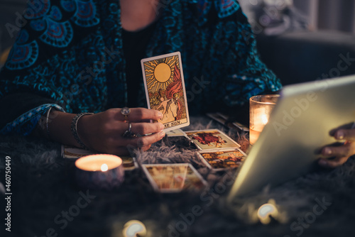 Fortune teller showing tarot cards online. Online tarot cards with tablet or smartphone. Astrologists and horoscope online concept.