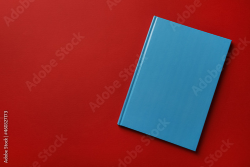 New stylish planner with hard cover on red background, top view. Space for text