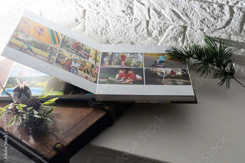 Luxury wooden photo book, wooden box with summer photos printed and flash card on linen natural background. Family memories photobook. Save your summer vacation memories. Photo album with wooden cover