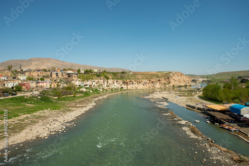 Waters of the Tigris river as it passes through the city of Hasankeyf with a cliff full of caves in an area of Mesopotamia