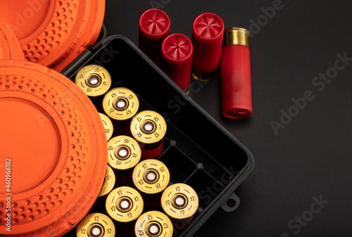 Clay shooting target with shotgun shell and box on black slate background , Shotgun game