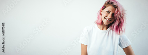 Positive plus size model with white blank t-shirt and pink hear, empty grunge wall background, wide screen