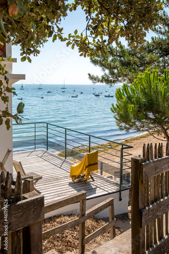 Terrasse en bois et chaise longue avec vue sur mer en France.