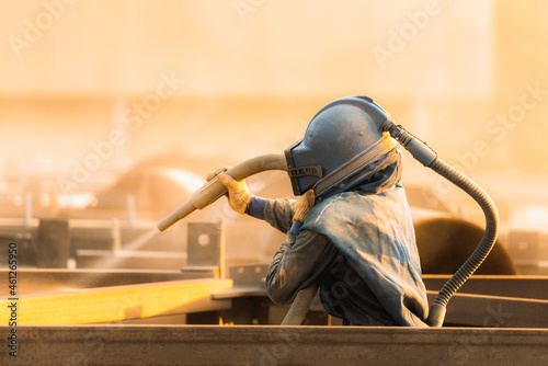 Sand blasting process, Industial worker using sand blasting process preparation cleaning surface on steel before painting in factory workshop.