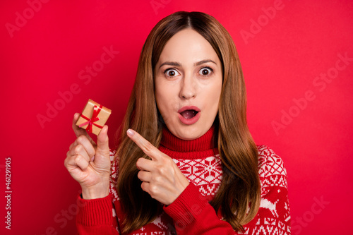 Portrait of attractive trendy cheerful amazed girl holding in hand demonstrating tiny giftbox congrats isolated over bright red color background