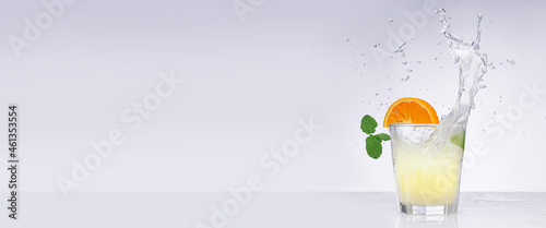fresh fruits falling into cocktail glass, splashing on white background