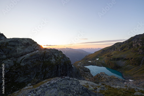 A wonderful view to the horizon at a beautiful sunset in the alps of Switzerland by an alpine lake called Schottensee. These colors by the sunset are just amazing. Epic clear blue water.