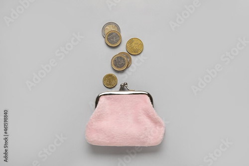 Pink wallet with coins on grey background