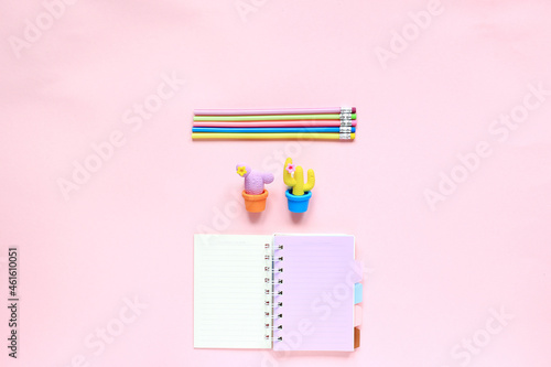 Items for drawing on a pink background. Layout from the sketching kit. Notepad, eraser and pencils on a pink background. View from above