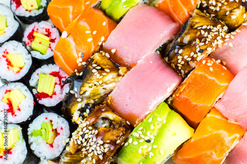 Tasty Colorful assorted Set of different type Sushi. Dinner in Japanese style. Healthy food. Filadelfia and Maki sushi rolls with Avocado, Tuna, Salmon, fish and Prawns. Close up view. Wallpaper.