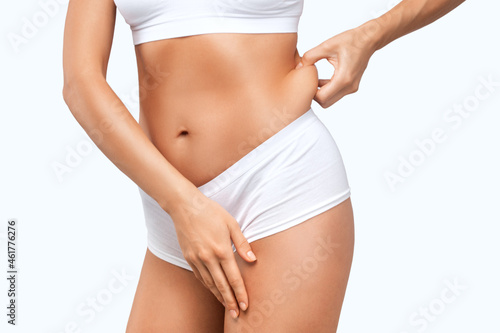 The woman shows off a thick waist. Treatment and getting rid of excess weight, the deposition of subcutaneous fat.