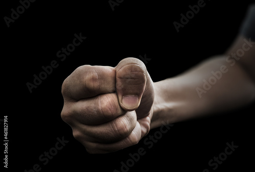 Selective focus shot of a male's fist on a black background