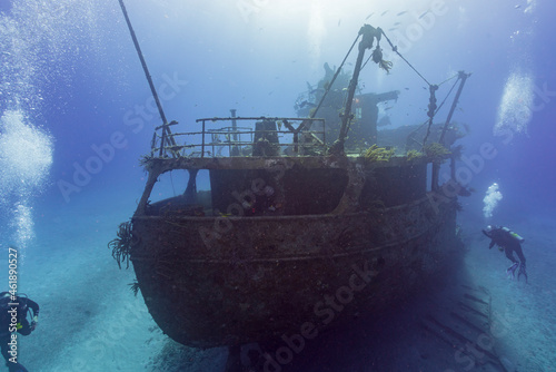 SCUBA divers exploring a shipwreck in tropical waters