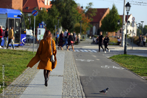 Piękna kobieta, dziewczyna spaceruje po chodniku, deptaku we Wrocławiu. 