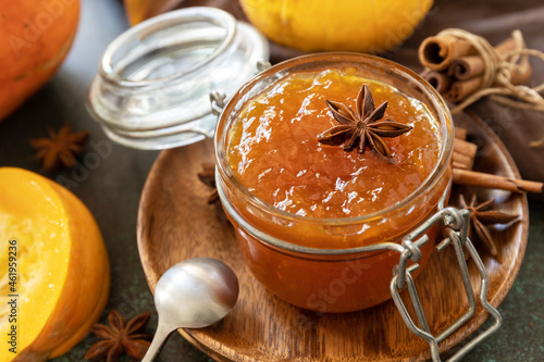 Homemade preserved, delicious sweet spicy sauce close-up. Pumpkin confiture, jam, chutney sauce with spices on stone table.