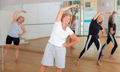 Elderly active women practice energetic dancing, engaged in a group lesson in the studio of dance