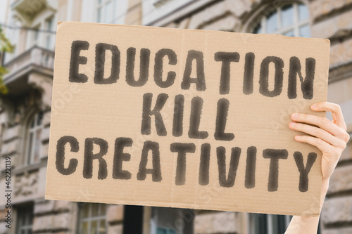 The phrase " Education kill creativity " on a banner in men's hand with blurred background. University. School. System. Dangerous. Study. Students. Knowledge. Occupation