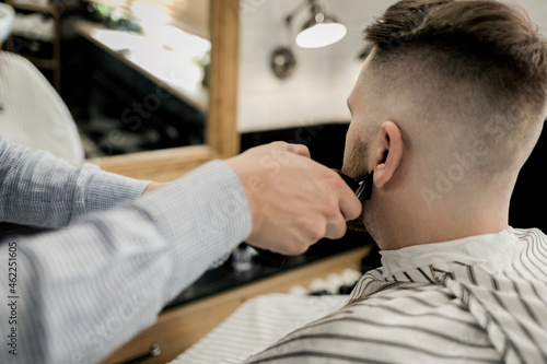 barber smoothes the beard