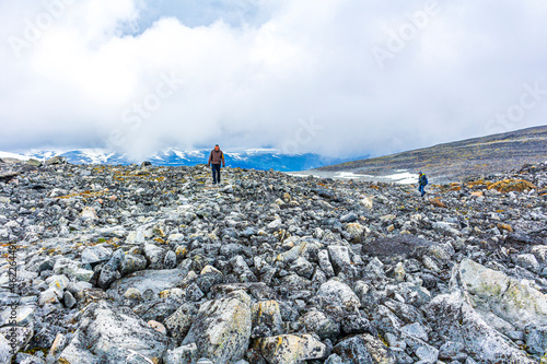 People hikers at largest highest mountain Galdhøpiggen in Norway Scandinavia.