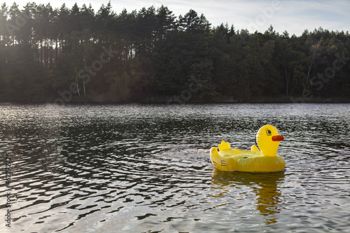 WIelka żółta dmuchana kaczka dryfująca samotnie po jeziorze