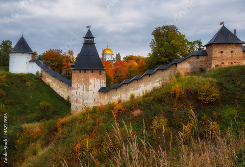 Powerful defensive walls and beautiful churches on the hills in the Dormition Pskovo Pechersky Monastery in the city of Pechery, Pskov Region, Russia during the golden autumn