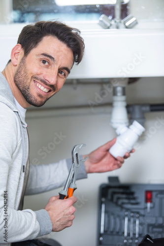 male plumber fixing sink pipe