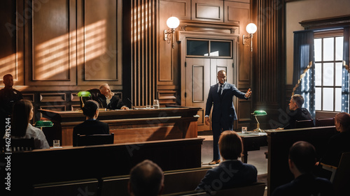 Court of Justice and Law Trial: Male Public Defender Presenting Case, Making Passionate Speech to Judge, Jury. African American Attorney Lawyer Protecting Client's Innocents with Supporting Argument.