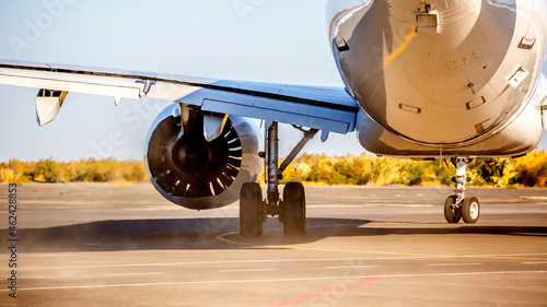 The plane is preparing to fly at the airport. Airplane on the runway at the airport. The turbine of the aircraft is warming up, the landing gear is preparing for flight. The plane flies in the sky.