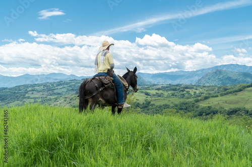 Man riding horse with natural landscape view. Tamesis, Antioquia, Colombia.