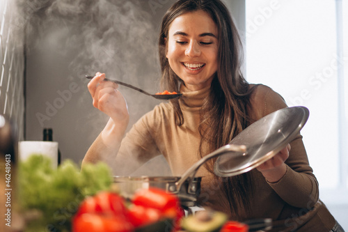 Woman cooking soup at kitchen