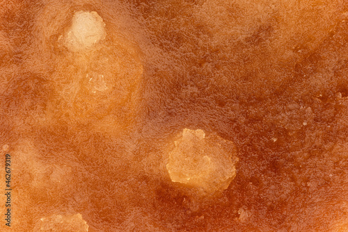 Crystalized honey - almost solid amber coloured substance, closeup detail image width 23mm