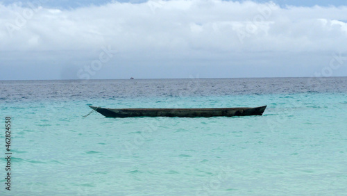 Wooden Canoe Drifting On Zanzibar Clear Ocean On A Cloudy Morning Along The Nungwi Beach