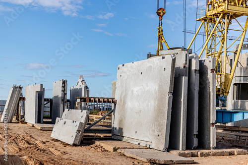 Many precast concrete wall panels are stocking in the storage area waiting for installation at construction site.
