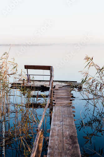 Drewniany pomost nad jeziorem, mglisty poranek nad jeziorem z pomostem, ławeczka nad jeziorem, wschód słońca nad jeziorem z pomostem 