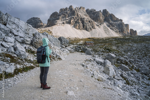 Woman with backpack hiking in Tre Cime National park. Dolomites, Italy, Europe