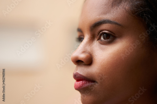 Close up portrait of attractive African American woman's eyes looking outside through window.